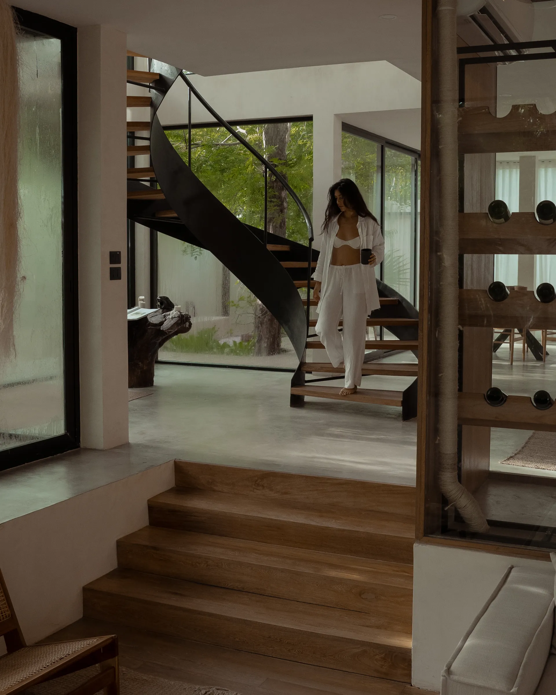Woman descending stairs at Casa Nati with wine cellar and jungle views