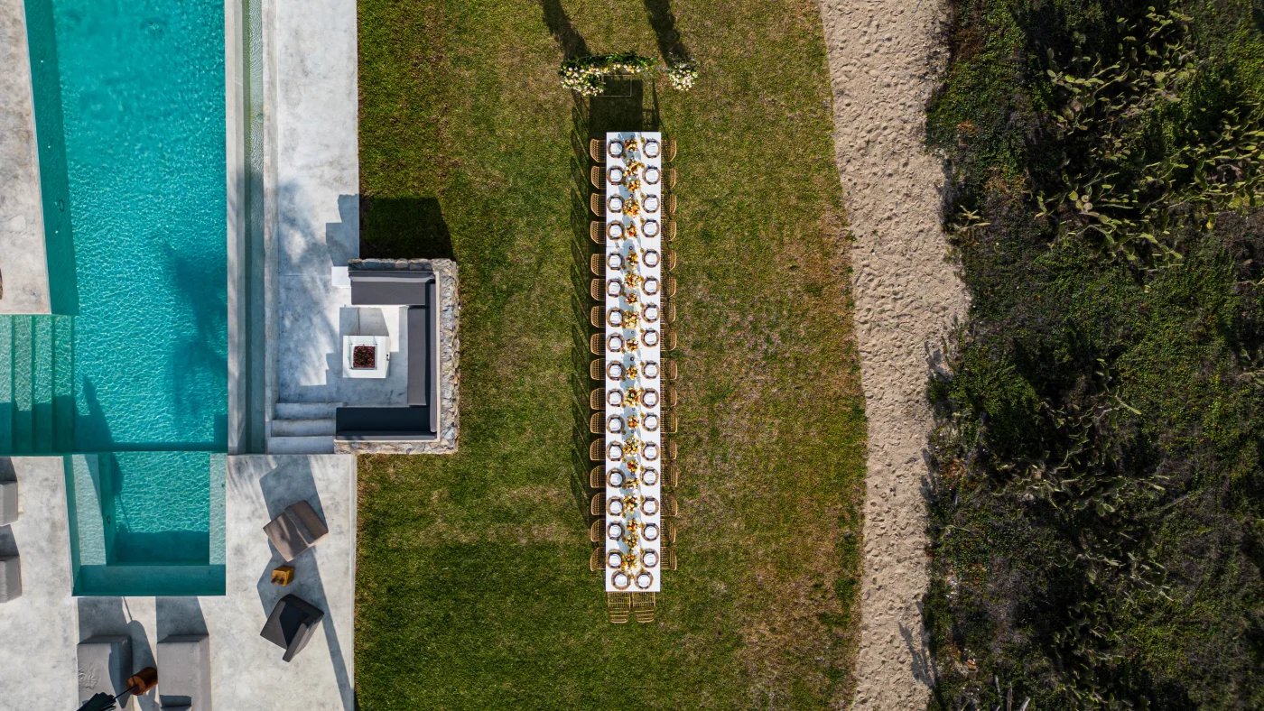 Aerial view of elegant wedding dinner setup at oceanfront villa