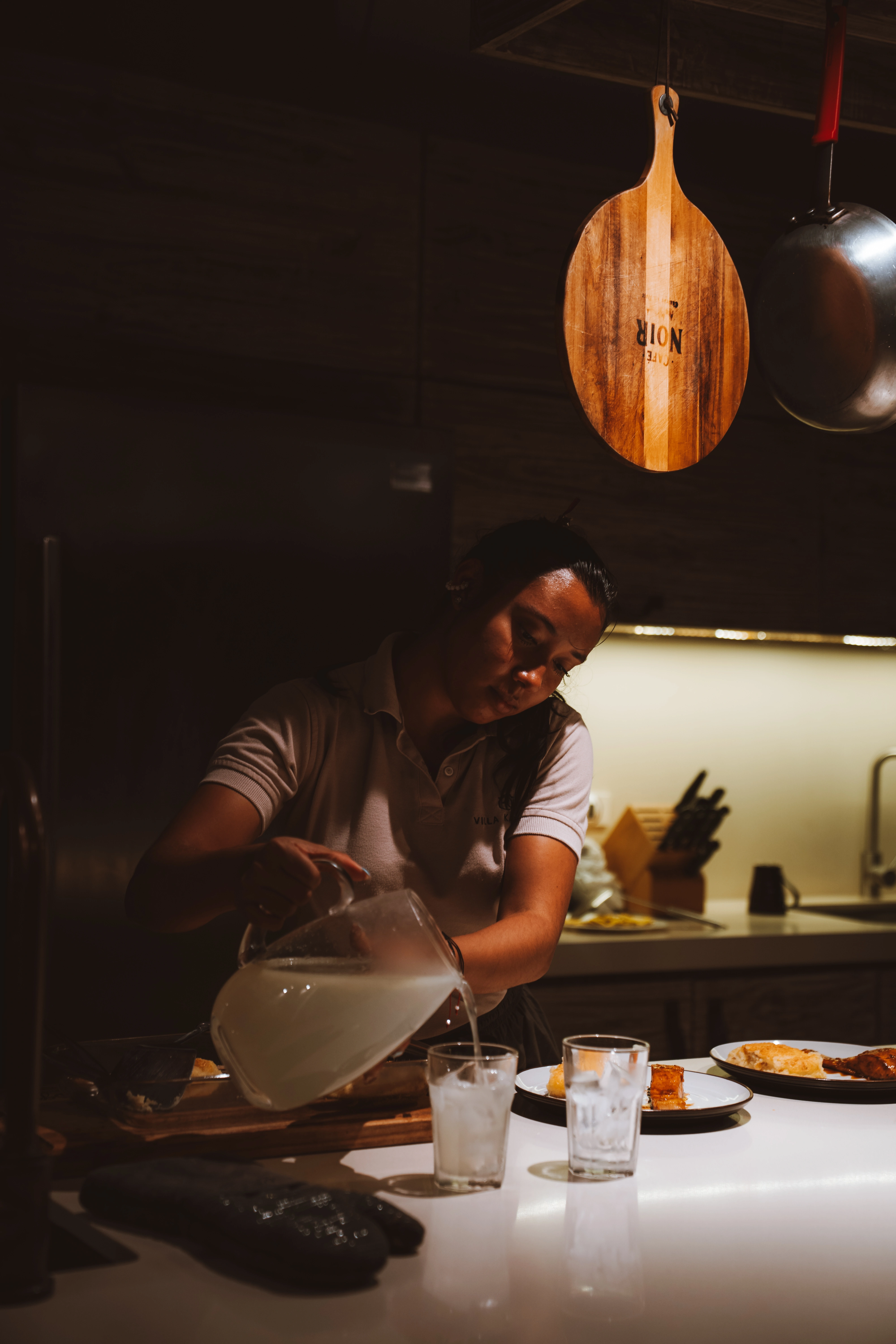 Private chef pouring fresh lemonade while preparing dinner service