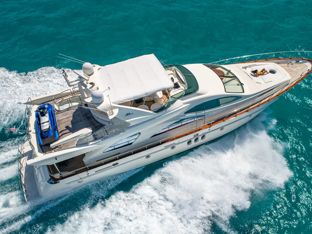 Aerial of the Azimut 84 under way over turquoise water with a full wake, a World Cup off-day charter from Miami