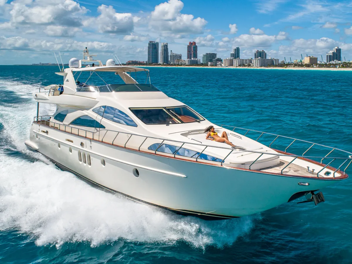 Azimut 84 cruising past Miami Beach skyline with guest sunbathing on bow