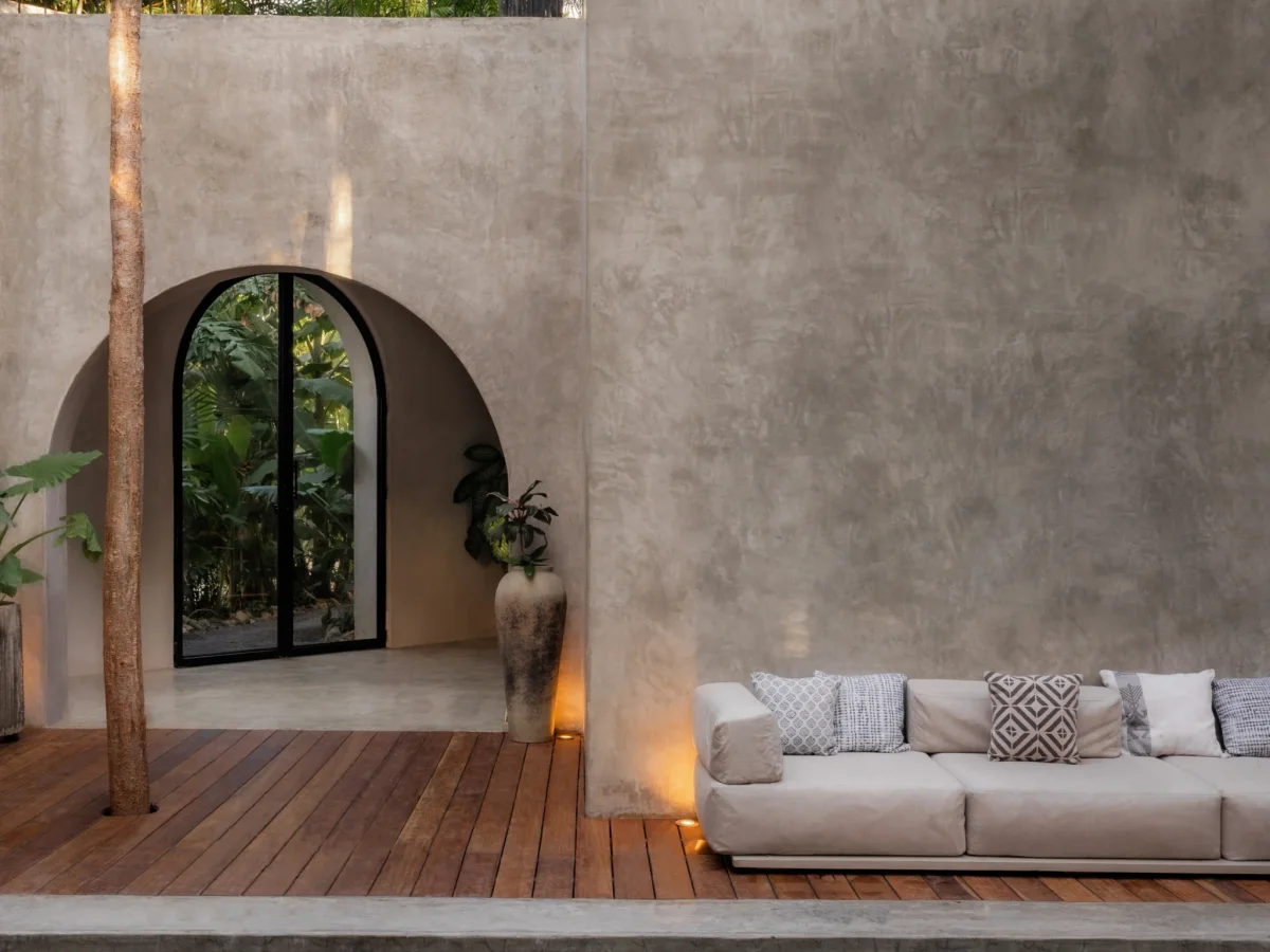 Poolside terrace at dusk with arched doorway and jungle backdrop at Casa Shalva, Tulum