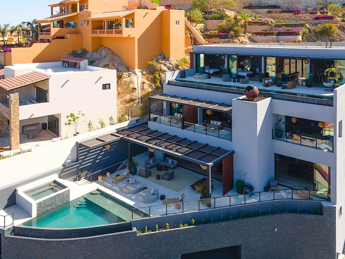 Eight-bedroom Pedregal estate at dusk with lit infinity pool overlooking the marina and Sea of Cortez