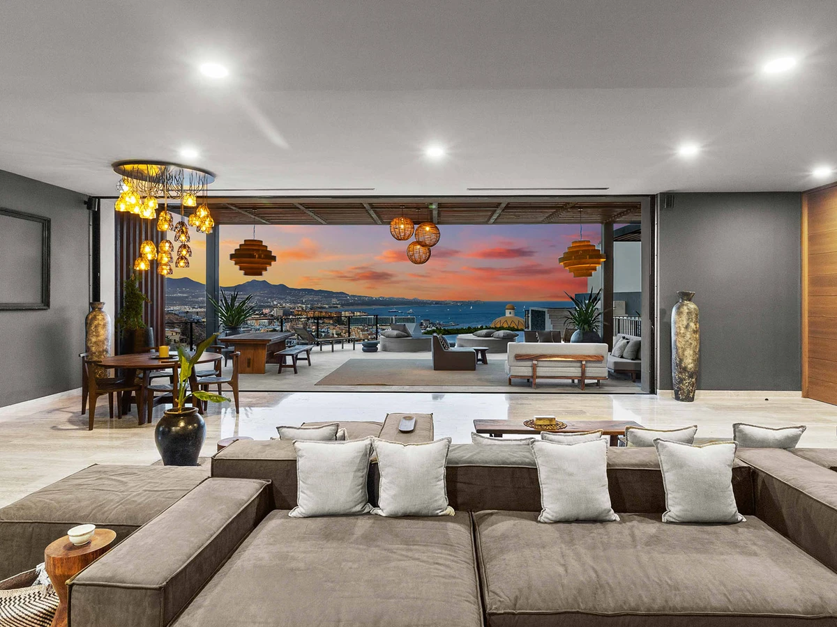 Outdoor dining and lounge area at a Cabo villa at sunset