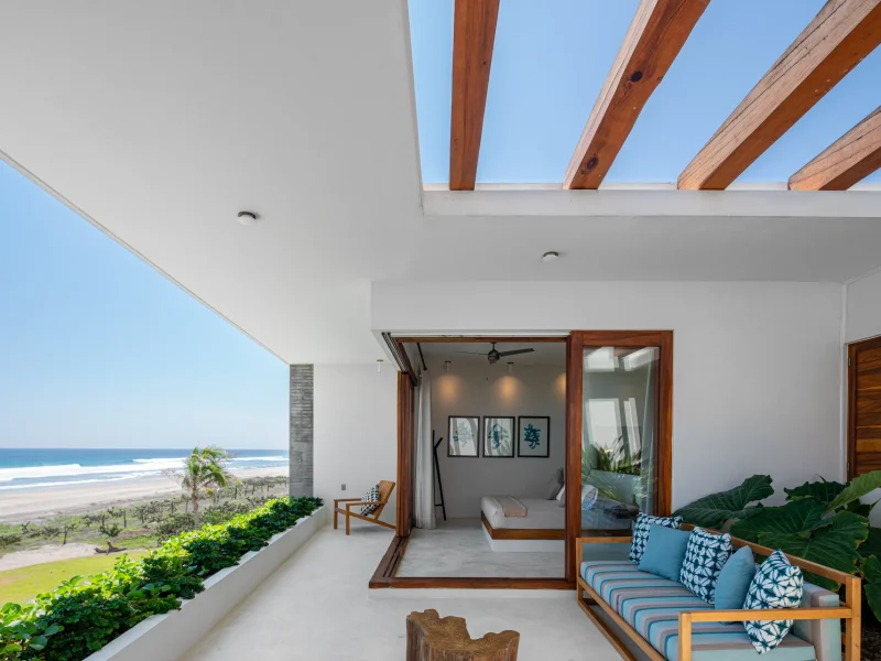 Large staffed villa terrace set for a group dinner with lit pool behind