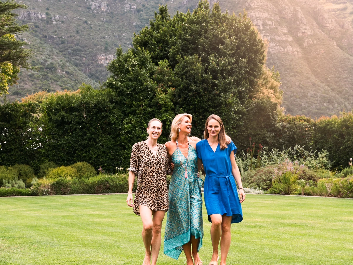 A family on the lawn of a Cape Town villa with Table Mountain rising behind