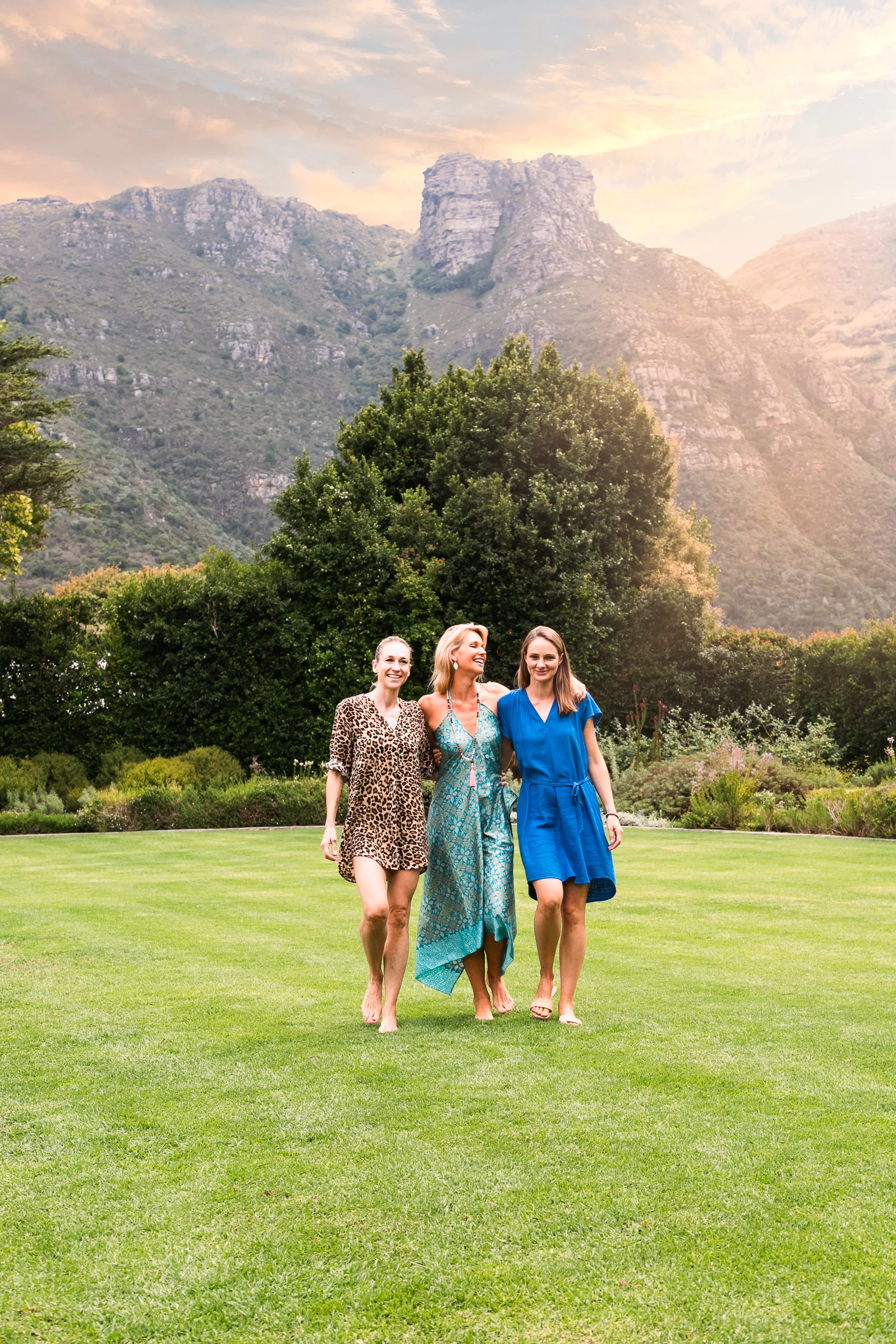 A family on the lawn of a Cape Town villa with Table Mountain rising behind