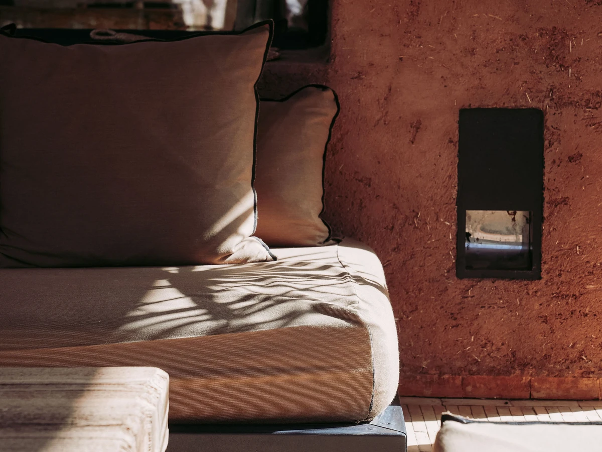Villa 79 swimming pool at sunset, Marrakech, with floating stone daybeds and mature olive trees