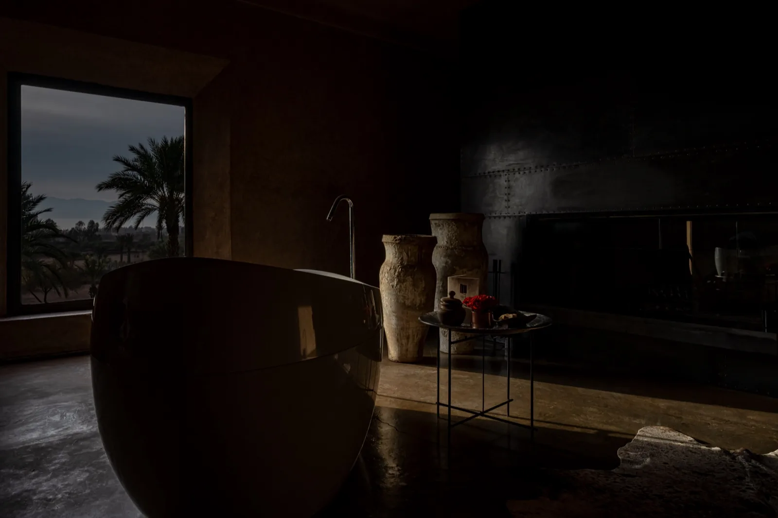 Villa D Marrakech pisé rammed-earth exterior at sunset with the Atlas Mountains in the background