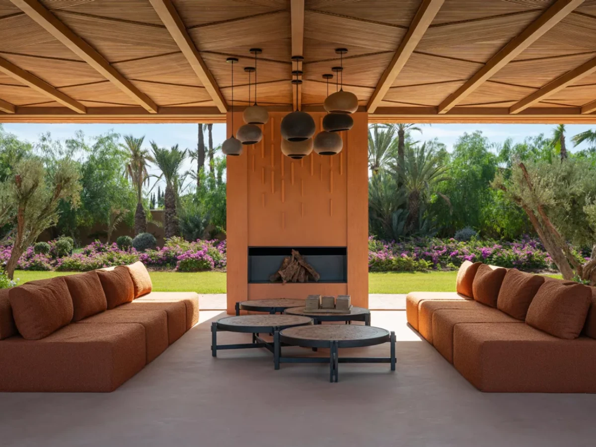 Main salon at Villa Kemgia with carved cedar ceiling, U-shaped sofa, and Moroccan art