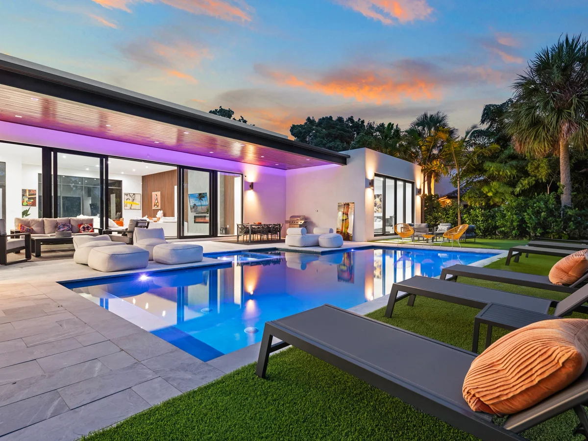 Villa Pesara at dusk, lit pool and open glass living wall, a Miami World Cup group base after a match