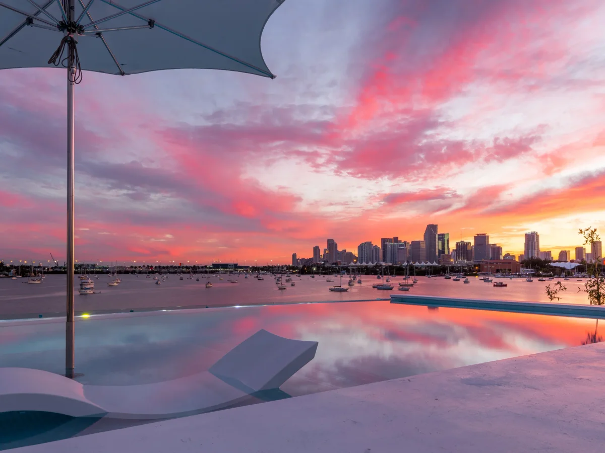 Infinity pool at dusk with the Miami skyline reflected in the water, the non-cash value a hotel block cannot price