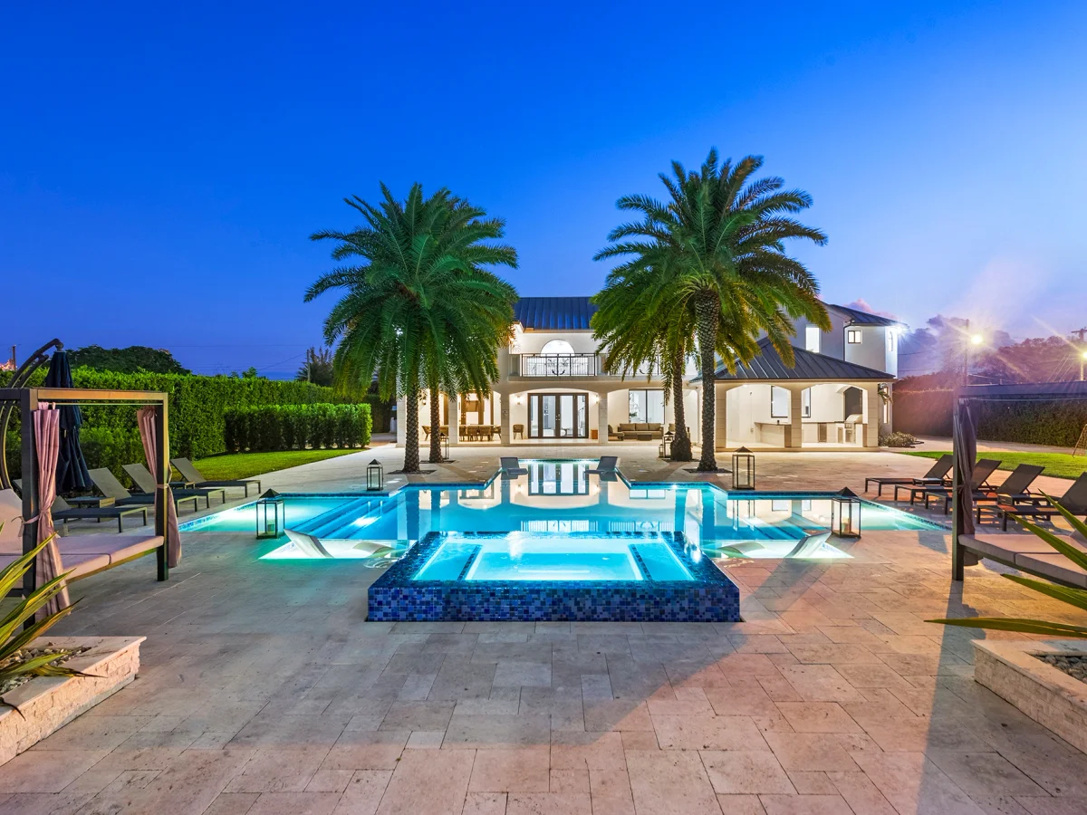 Waterfront terrace and dining area at a Miami villa in the evening